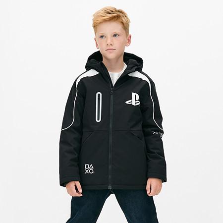 Child wearing a black PlayStation branded winter jacket with white trim and logo details.