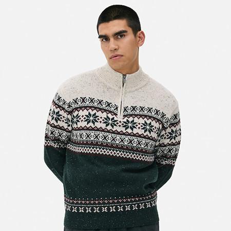 Cream and green winter sweater with Nordic pattern and quarter-zip neckline.