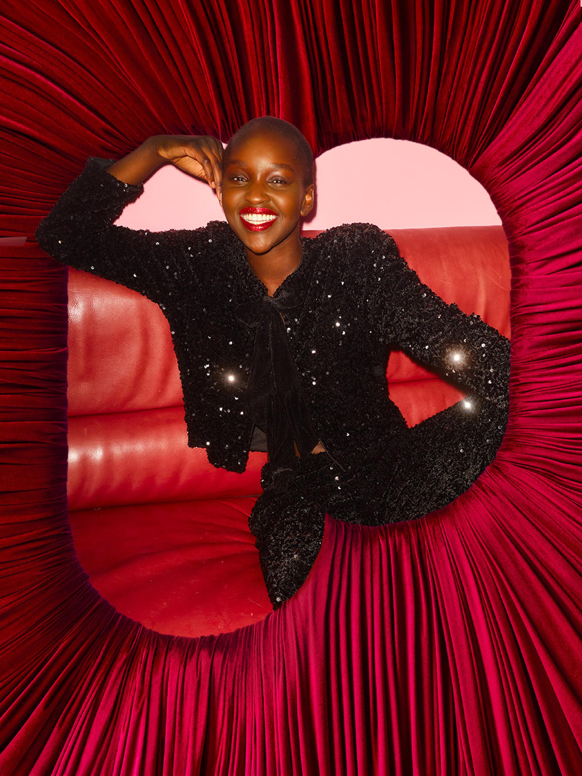 Person wearing pink crop top and leggings with black cap and leopard print crossbody bag against orange wall.