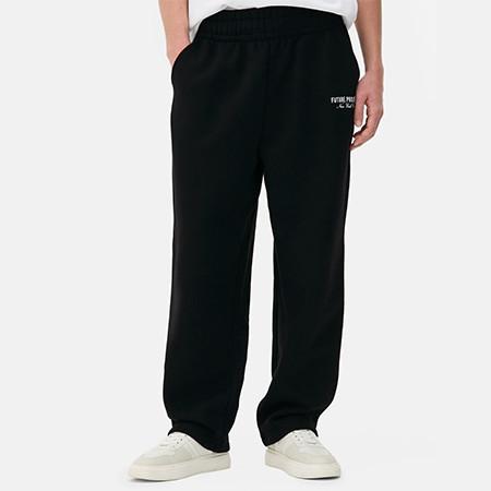 Black sweatpants with small logo on the hip, worn with white trainers and partial white top visible.