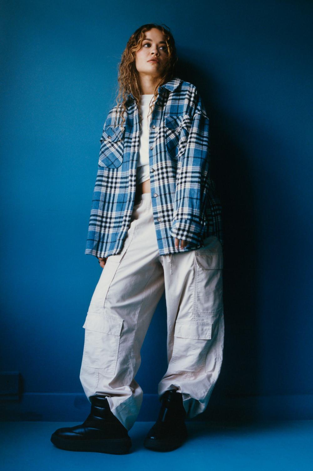 Model in gray cargo pants, white crop top, blue check shacket