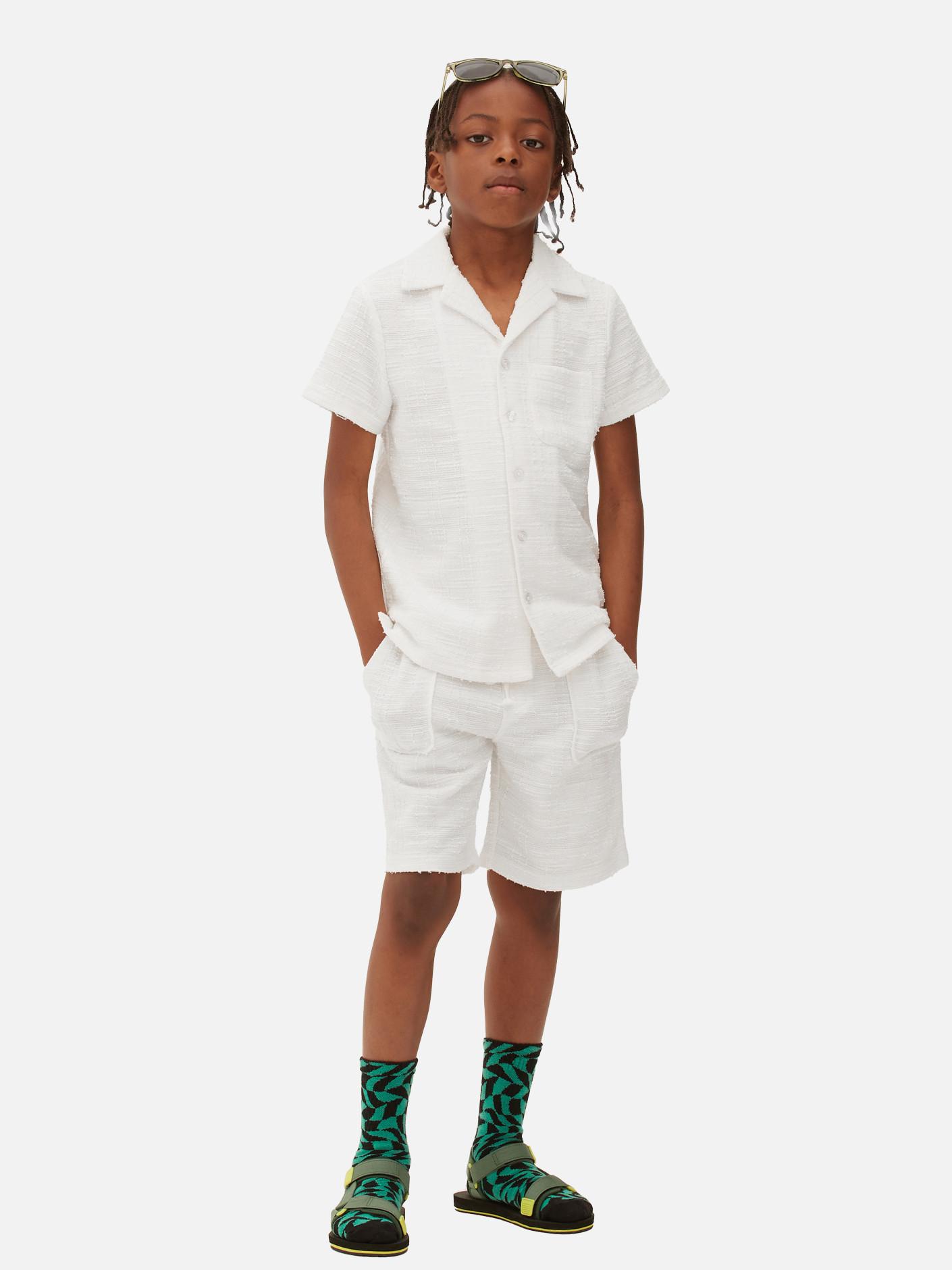 Child wears white shirt and chino shorts