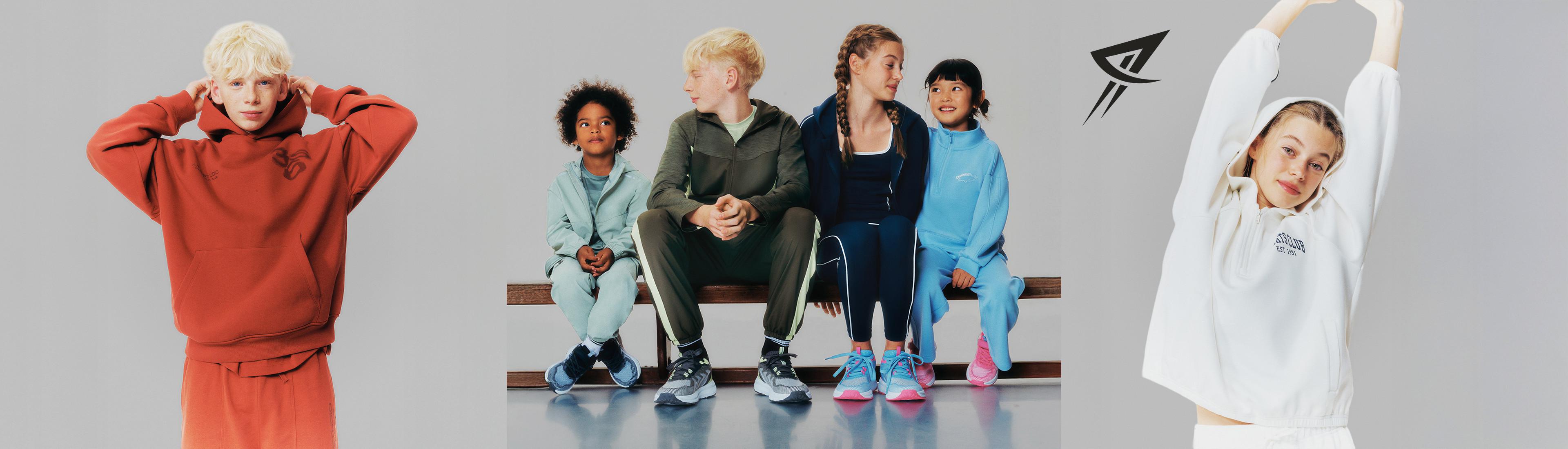 Children wearing colorful sportswear with four seated on wooden benches and two standing at either side.