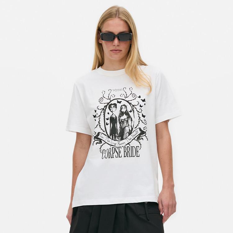 Person wearing black sunglasses and a white t-shirt featuring Corpse Bride movie characters and text.
