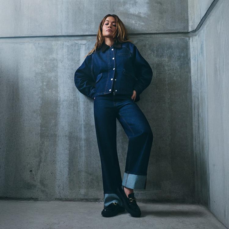 Model wearing blue denim jeans, blue jacket and black shoes