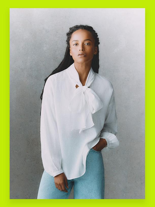 Model wearing white blouse and blue jeans