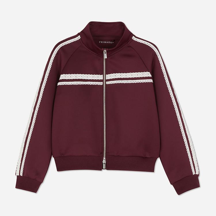 Burgundy Primark track jacket with white lace trim detail along sleeves and chest, featuring full zip front.