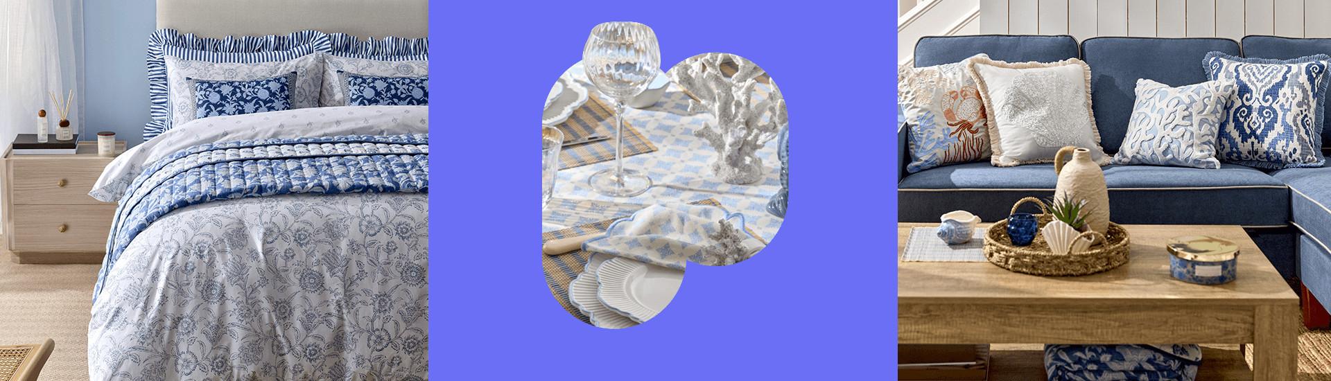Een collectie voor thuis met de kust als thema: blauw beddengoed met bloemenmotief, decoratief serviesgoed en een marineblauwe bank met bijpassende kussens en accessoires met kustprint.