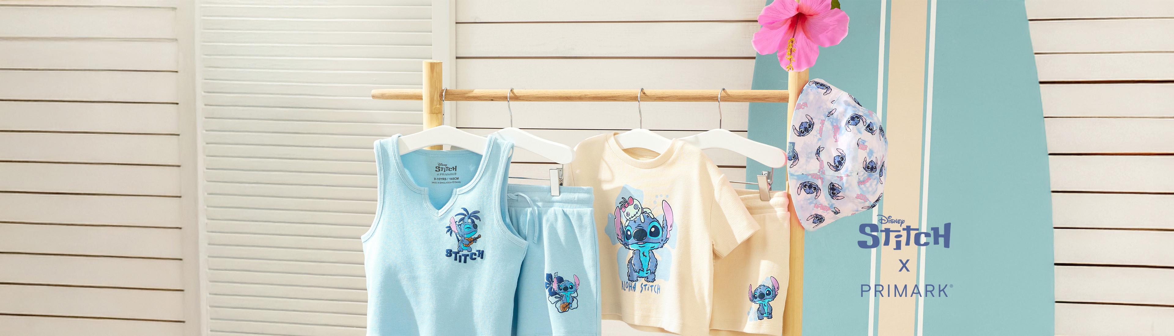 Produkte aus der Stitch-Kollektion präsentiert in einem Strand-Setting, darunter ein blaues T-Shirt mit passenden Shorts, ein gelbes T-Shirt mit passenden Shorts sowie ein Fischerhut