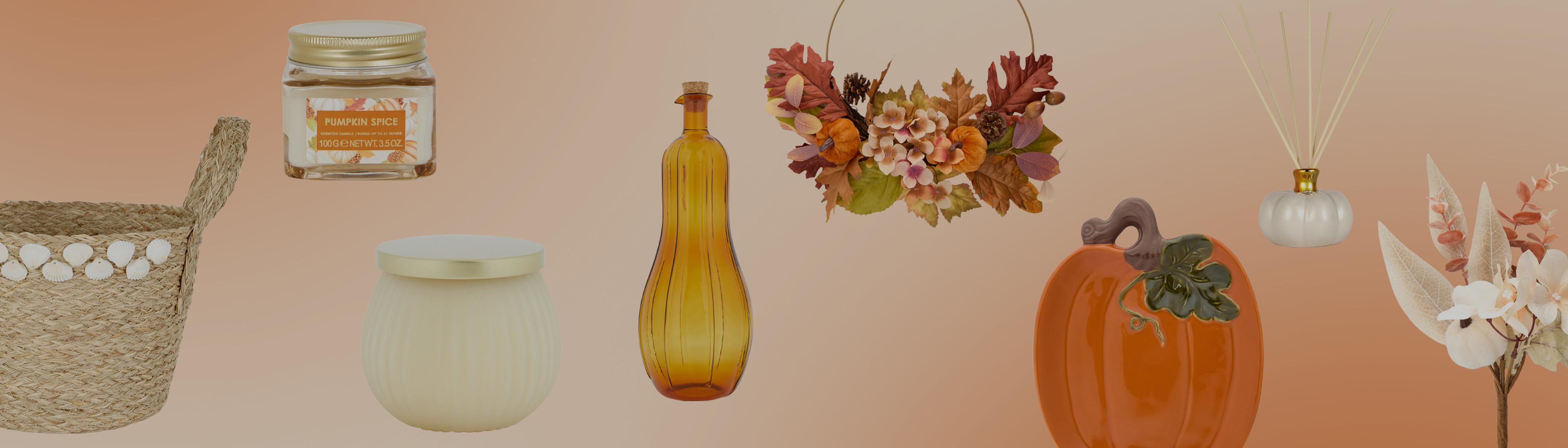 Coleção outonal para decoração da casa com vela de especiarias e abóbora, frasco âmbar, abóbora em cerâmica e coroa floral.