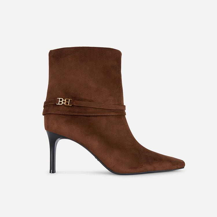 Brown suede ankle boot with pointed toe, thin heel and decorative strap with gold hardware detail.