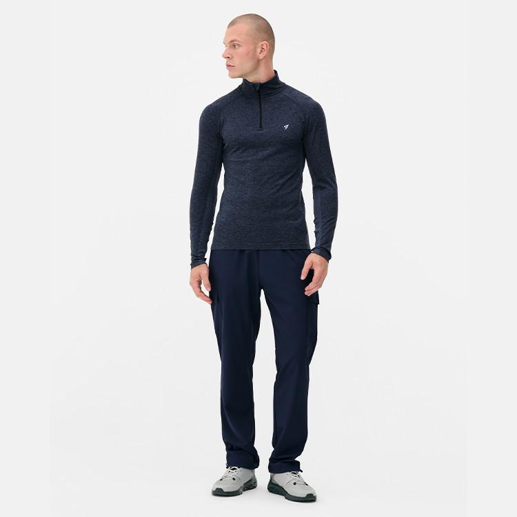 Person wearing navy quarter-zip athletic top with small logo and matching navy trousers.