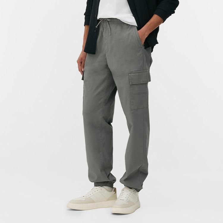 Tan corduroy trousers with wide legs, paired with brown shoes and a plaid shirt.