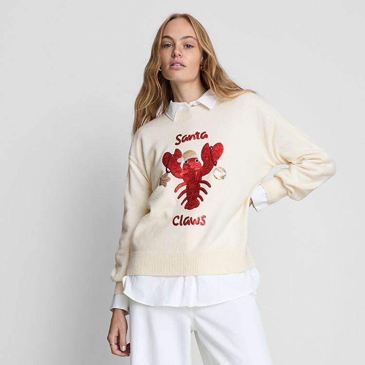 Cream jumper with sequined red lobster design and "Santa Claws" text, worn over white shirt.