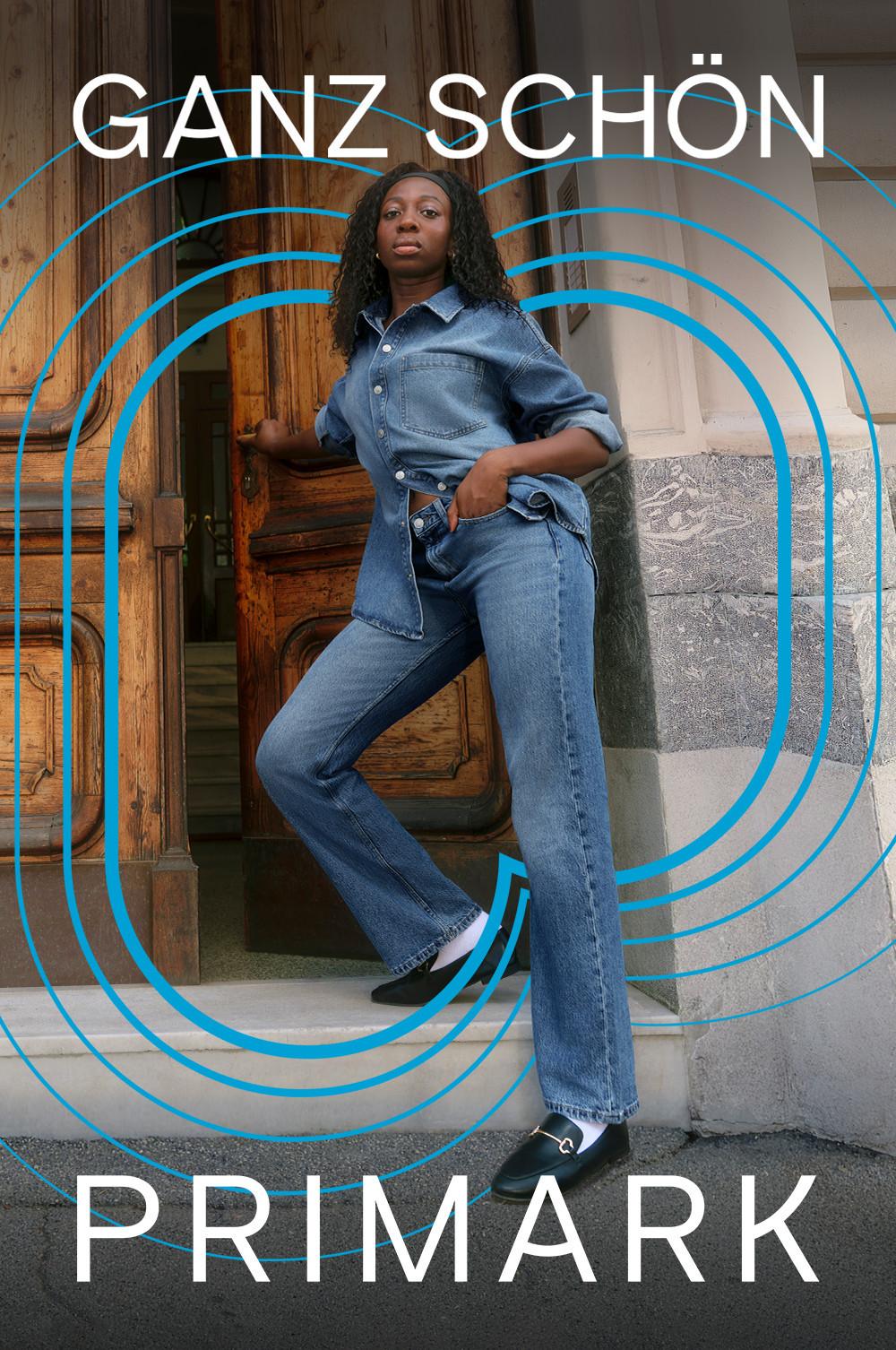 Eine Person posiert vor einer Holztür und lehnt sich leicht an. Sie ist komplett in Denim gekleidet und trägt ein Hemd mit Knopfleiste und dazu eine Jeans. Über das Foto sind blaue Linien gelegt, die sich zu Kreisen verschlingen.