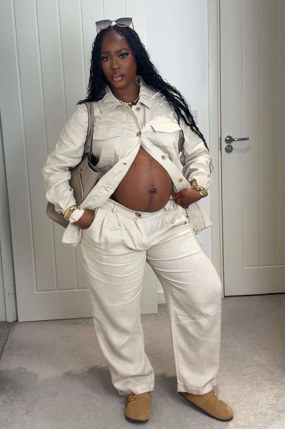 Model wearing cream linen shacket with matching cream linen trousers. Paired with brown clogs, brown shoulder bag and sunglasses.