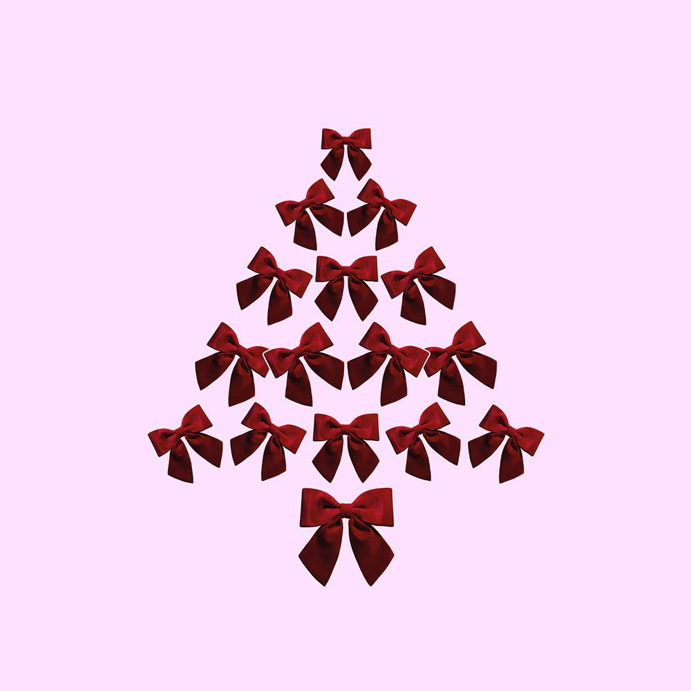 Rote Samtschleifen, in Form eines Weihnachtsbaums angeordnet, vor einem rosa Hintergrund.