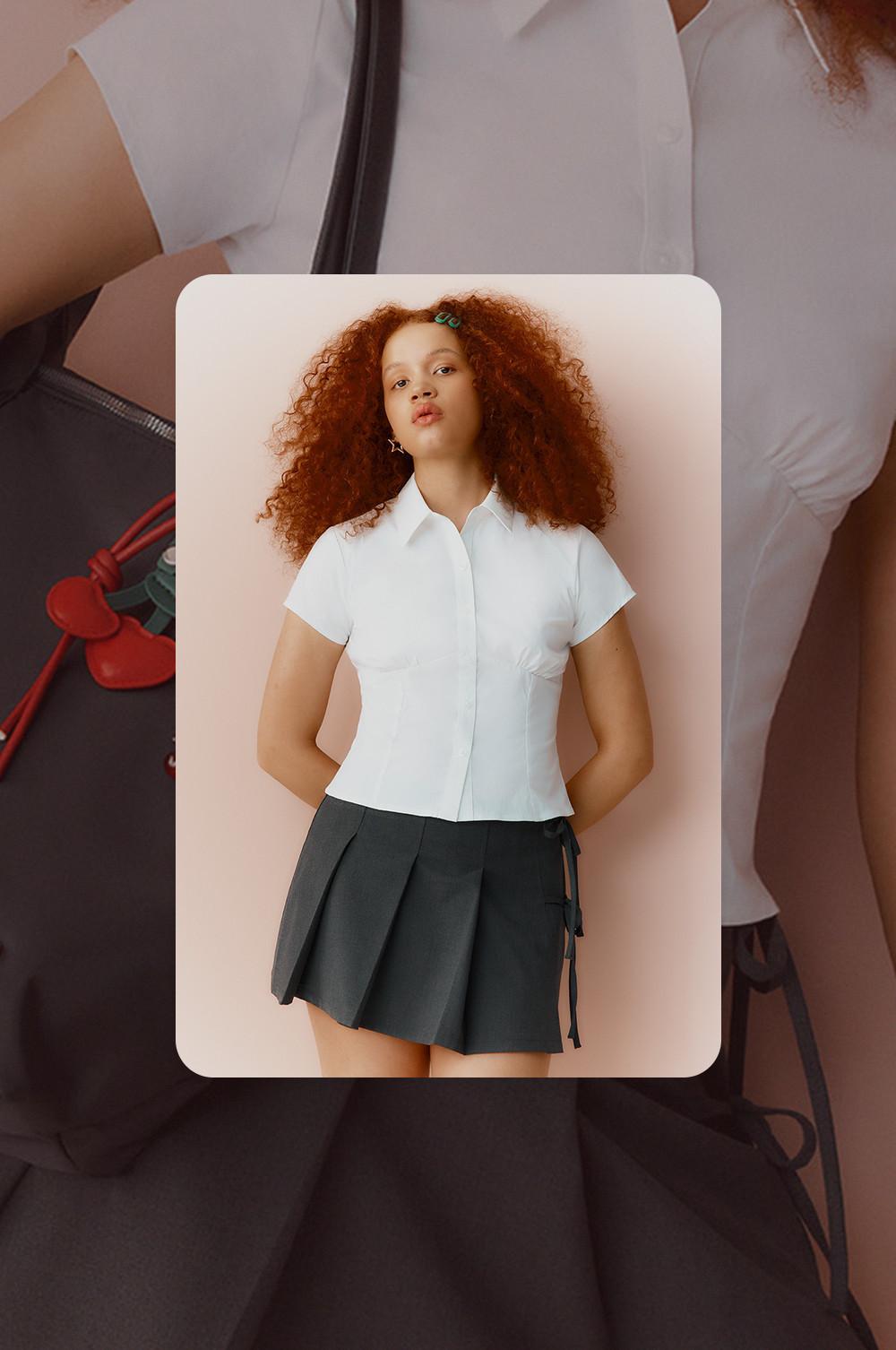Modella che indossa un top bianco e una gonna grigia