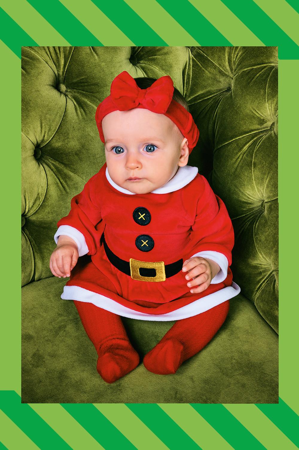 Baby trägt „Frau Claus“ Kleid und Strumpfhose