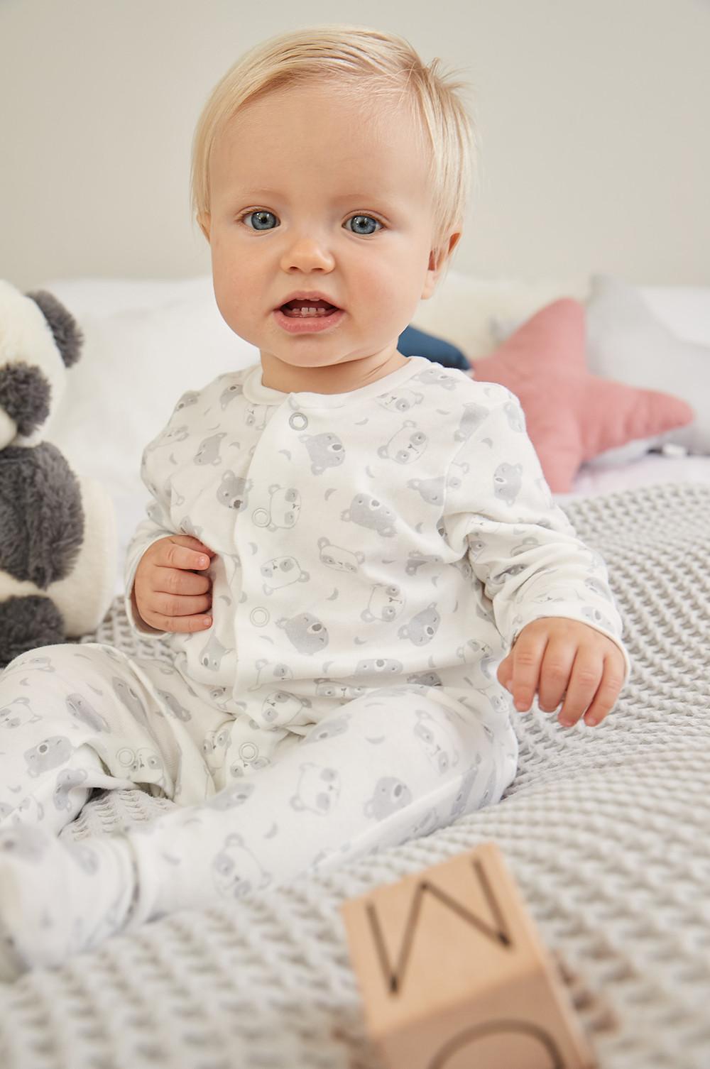 Bébé dans un babygros koala gris et blanc