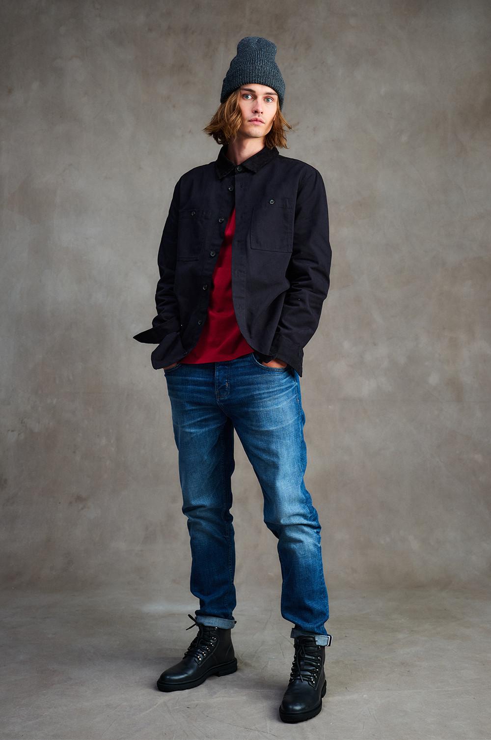 Model wears denim bootcut jeans and black jacket
