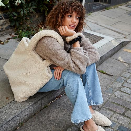 Model wears fleece jacket, shoes and bag