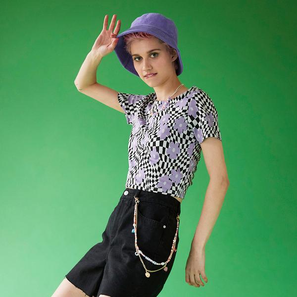 Model wears checked cropped blazer, with matching skort and green bodysuit