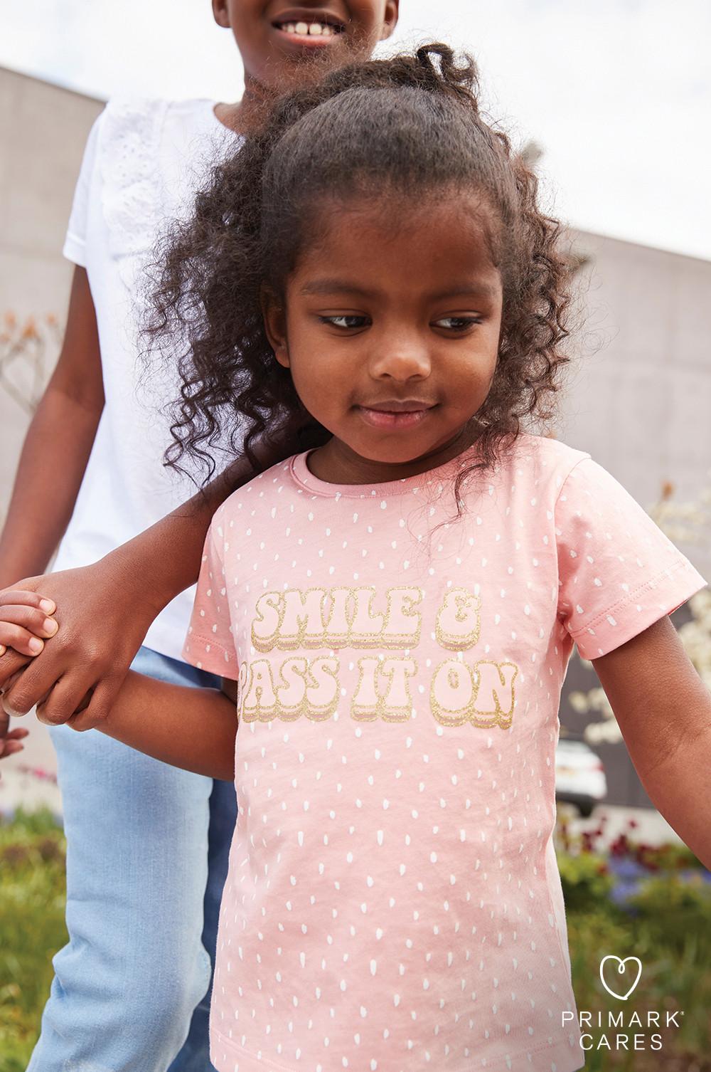 Mädchen mit geblümtem Slogan-T-Shirt in Rosa