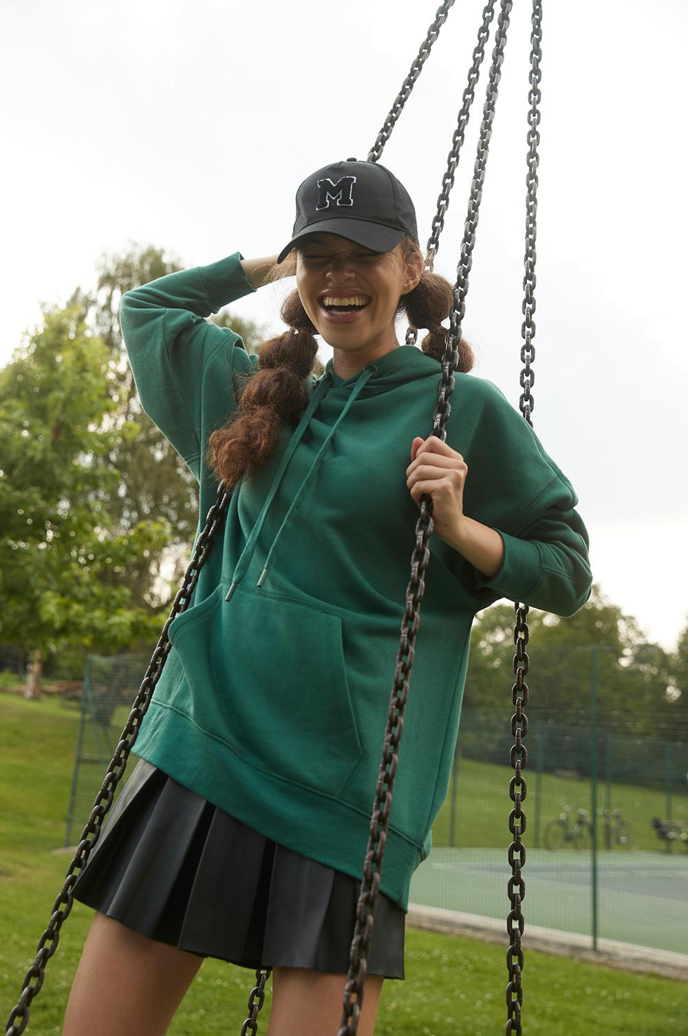 Model wearing green hoodie and black skort