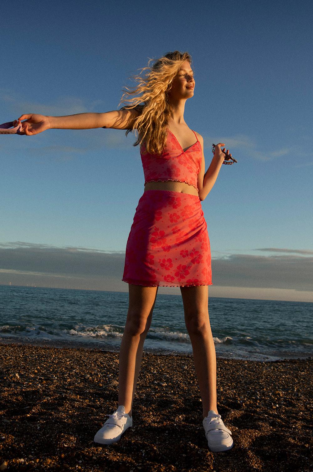 Model in abgestimmtem rosa Outfit mit Hibiskus-Print