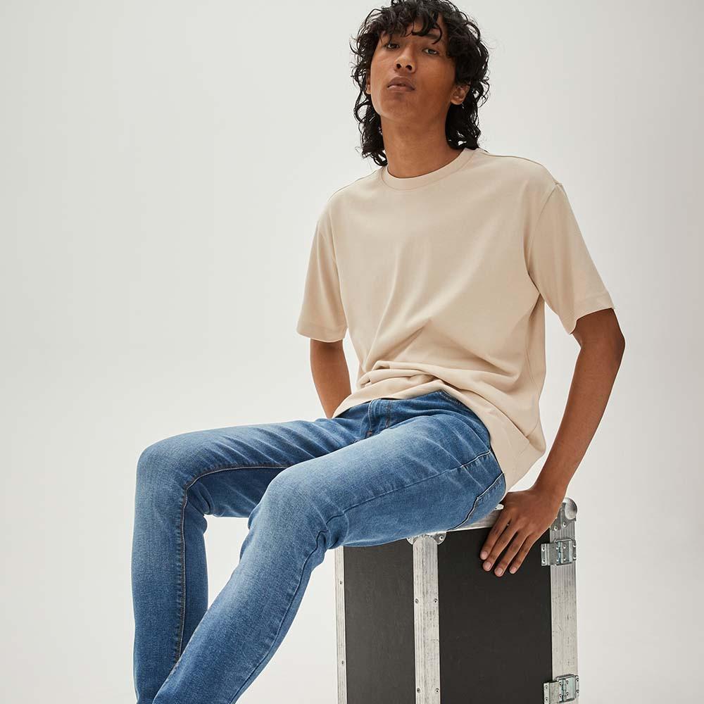 Le mannequin porte un jean skinny bleu et un T-shirt oversize gris pierre