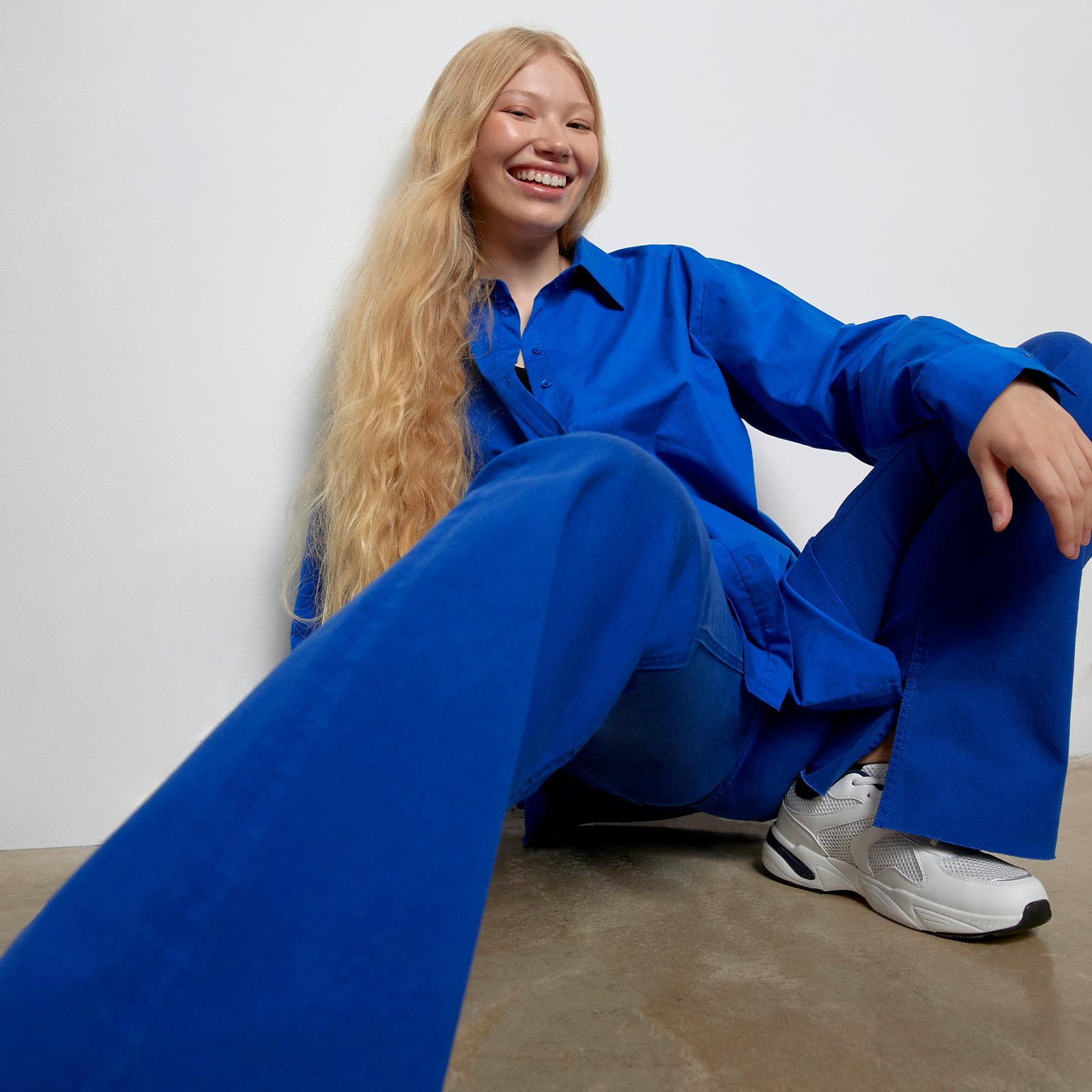 Model wearing electric blue flared jeans