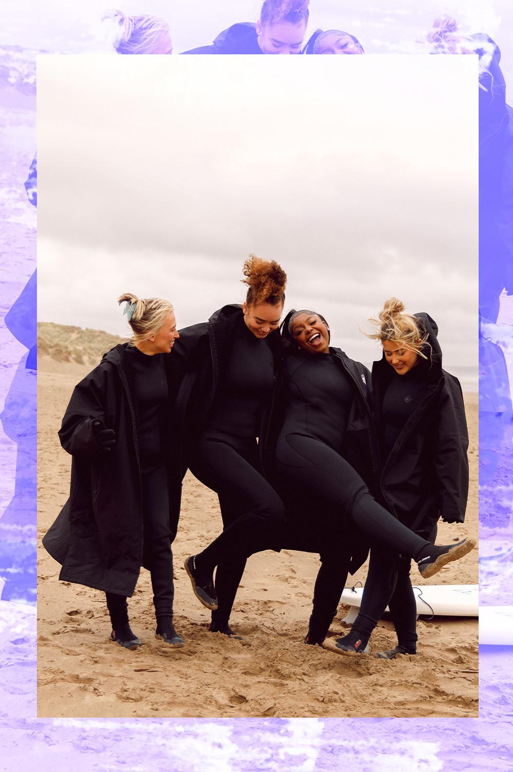 Influencers on the beach wearing black dry robes