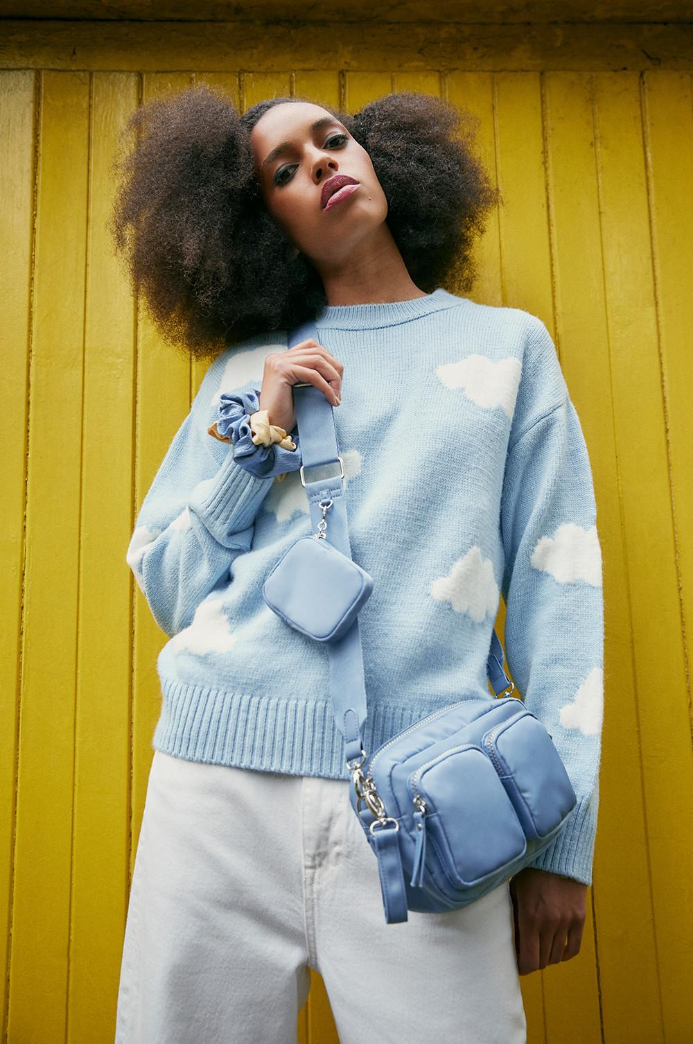 Model in blauem Pullover mit Wolken-Print