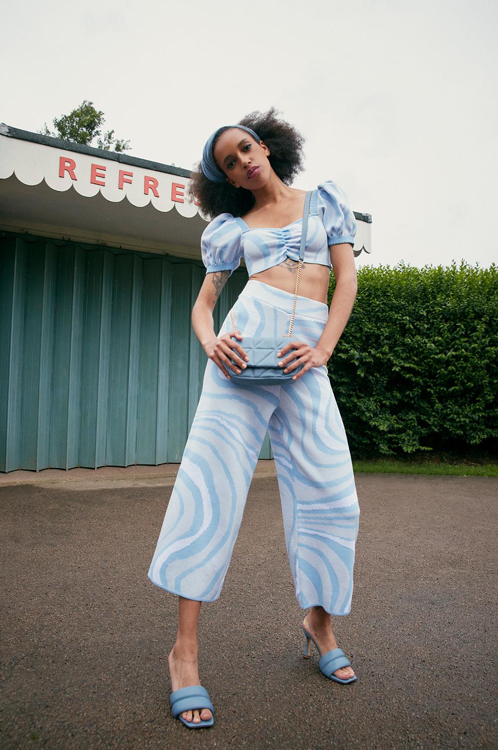 Model wearing blue knit top and trousers
