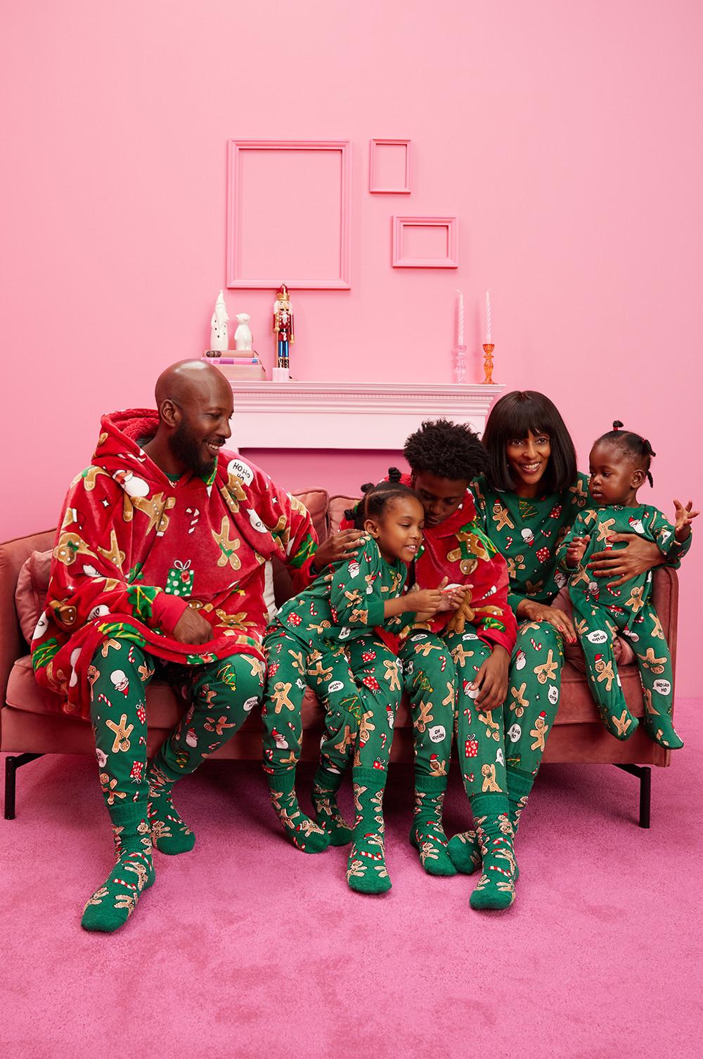 Famille portant des pyjamas de Noël verts et des snuddies verts