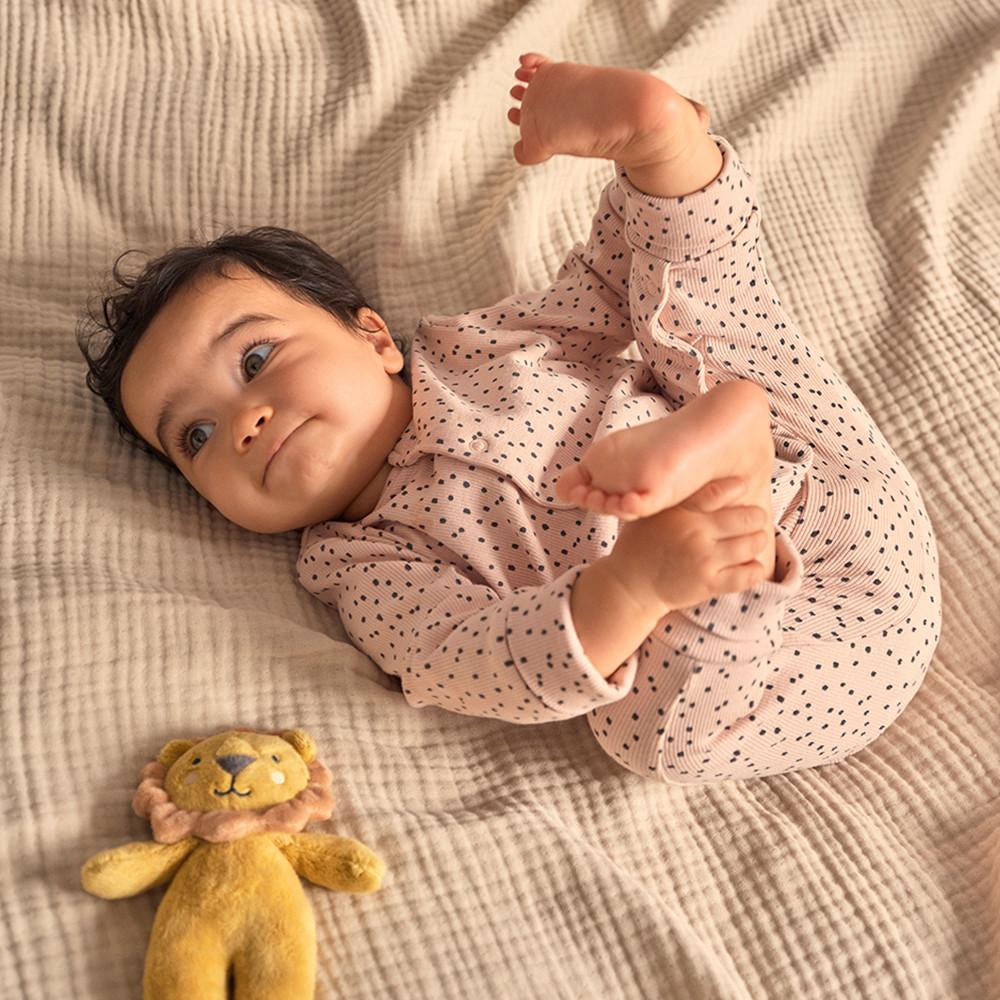 Baby laying down with lion toy