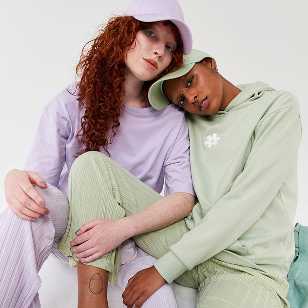 Models wear lilac and green sets with matching caps