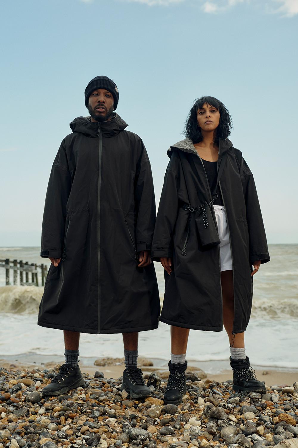 two models in black long thermal walking coats