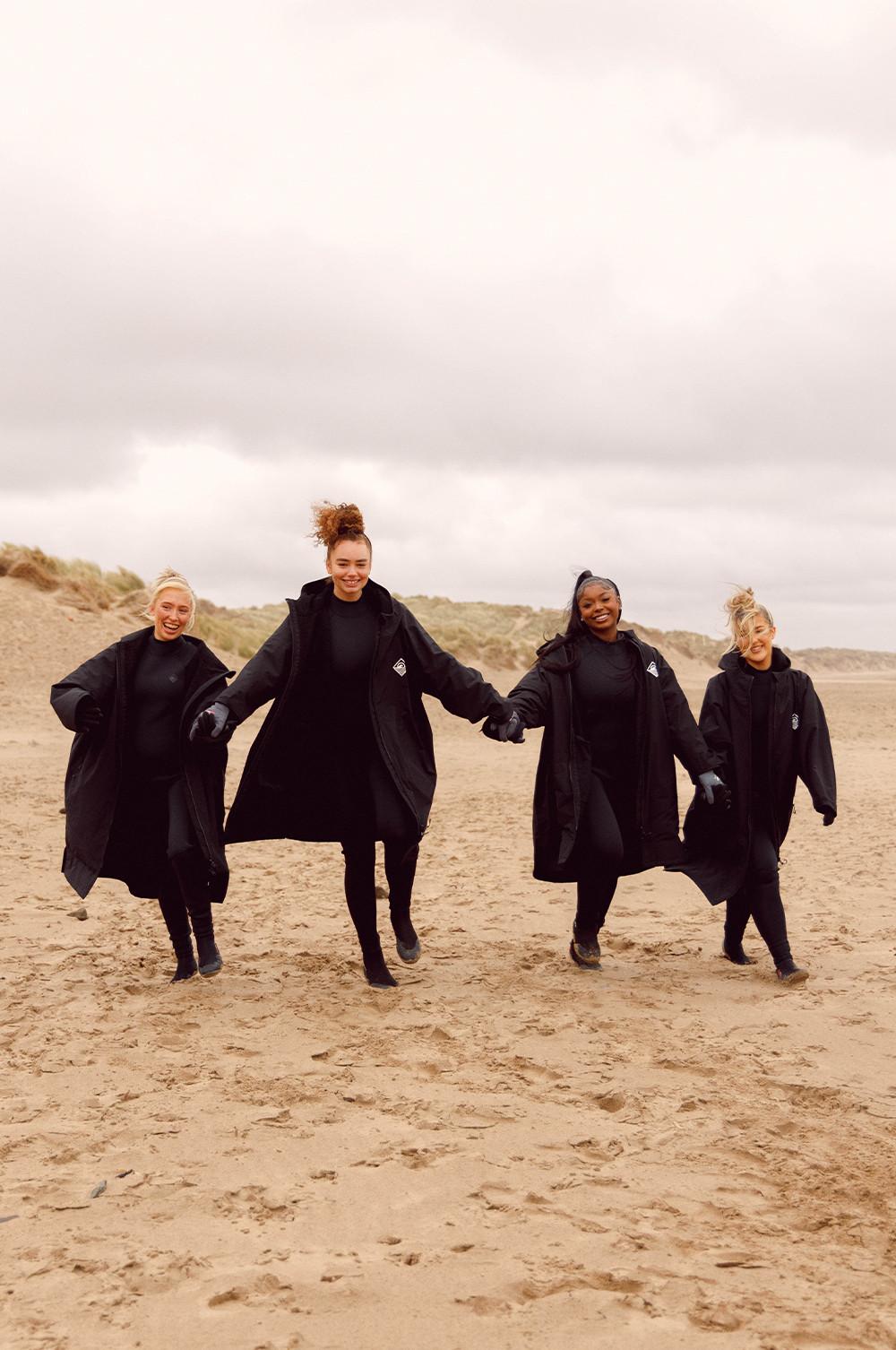Influencers wear black dry robes on the beach