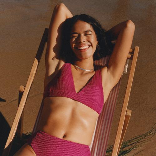 Model trägt einen pinken Bikini mit hohem Beinausschnitt