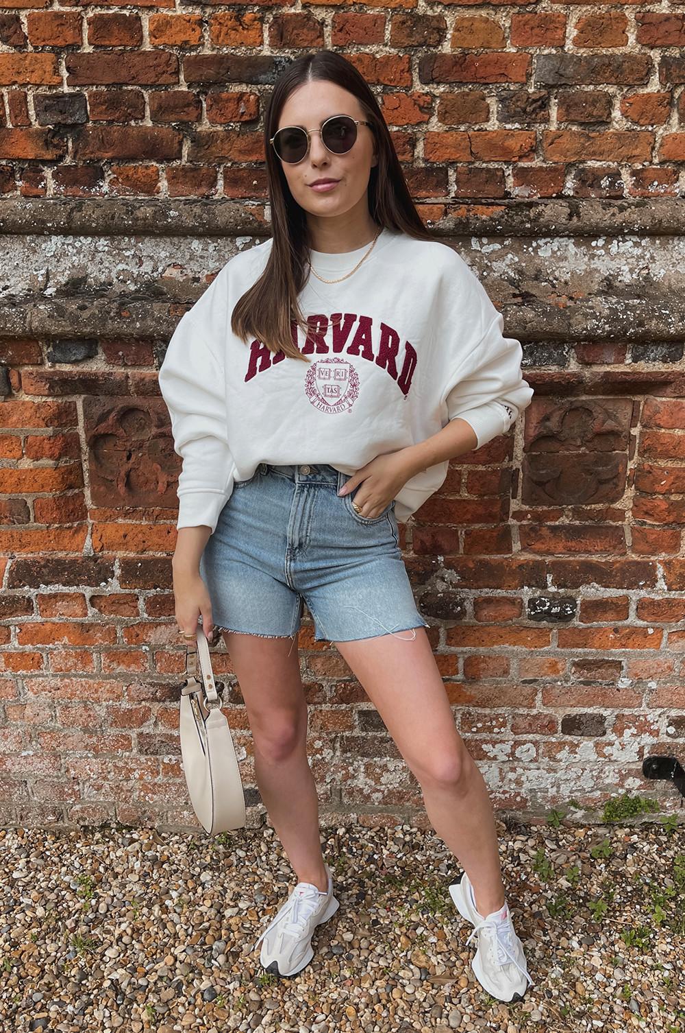Model wearing Harvard sweatshirt and denim shorts full size