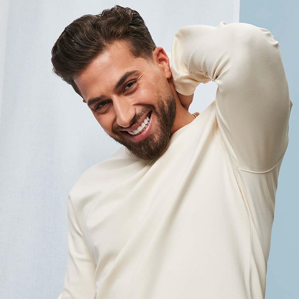 Kem Cetinay porte un sweat-shirt de couleur écrue