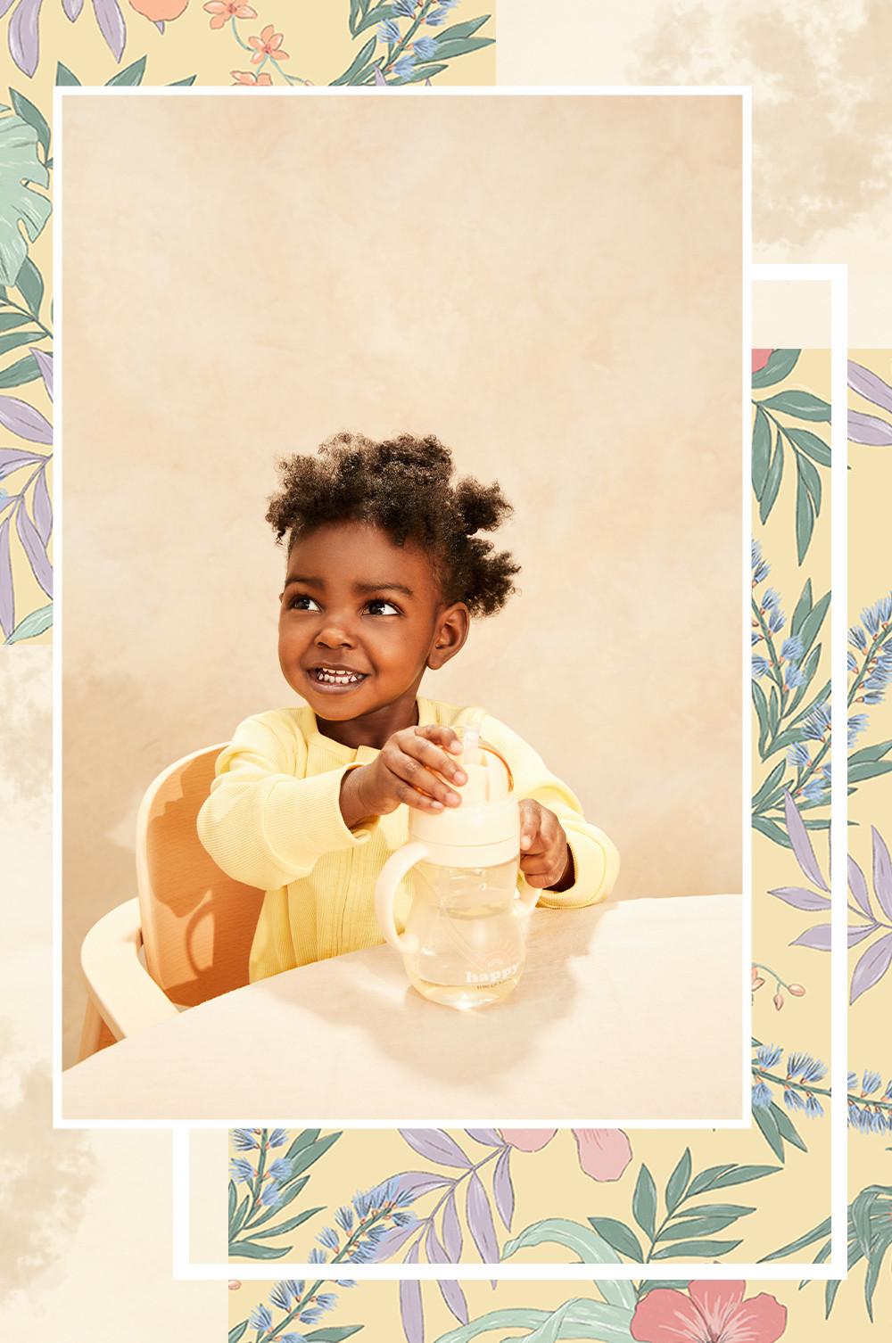 Child with a yellow beaker wearing a yellow ribbed sleepsuit