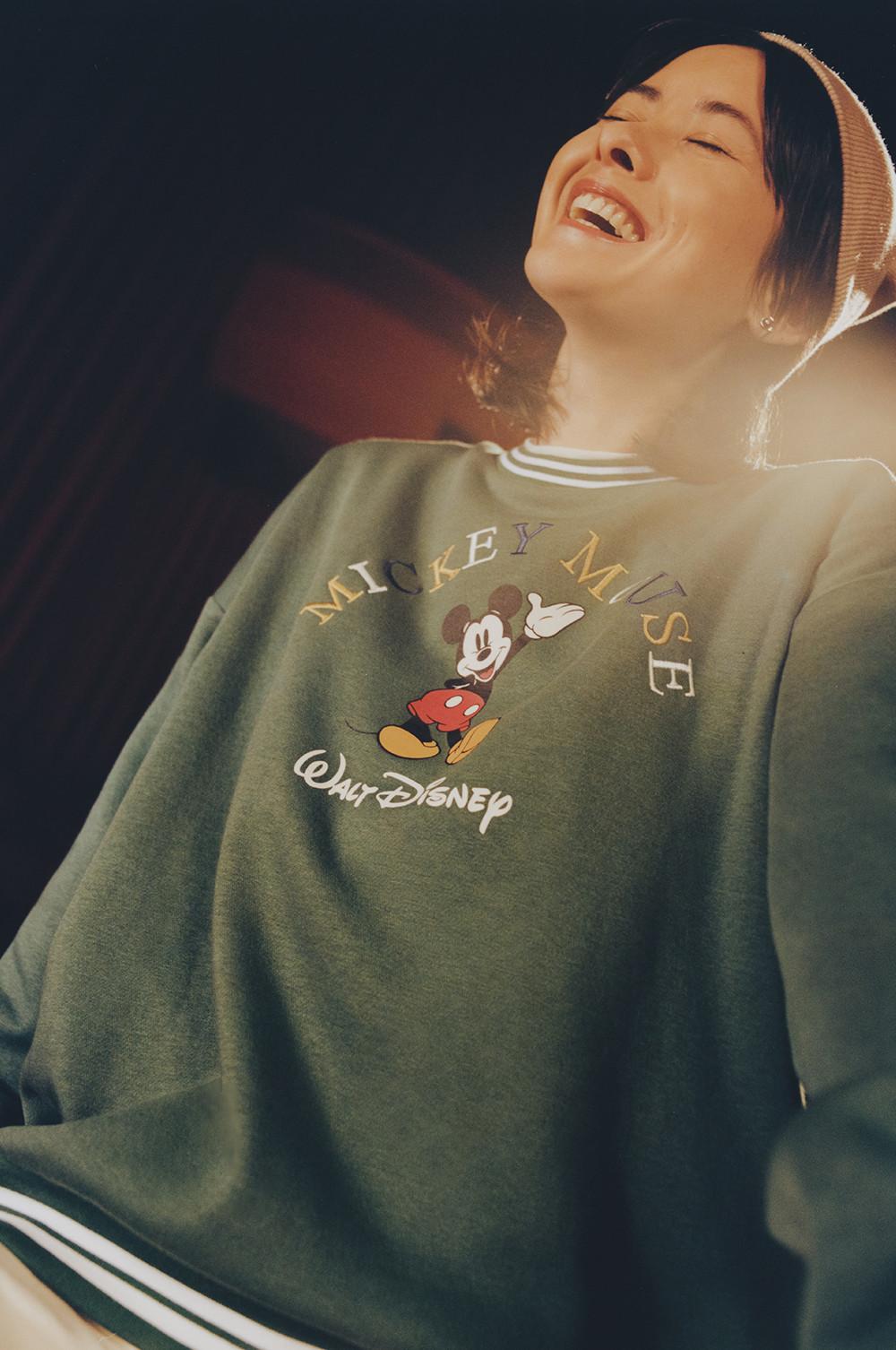 Model in een groen Mickey Mouse-sweatshirt