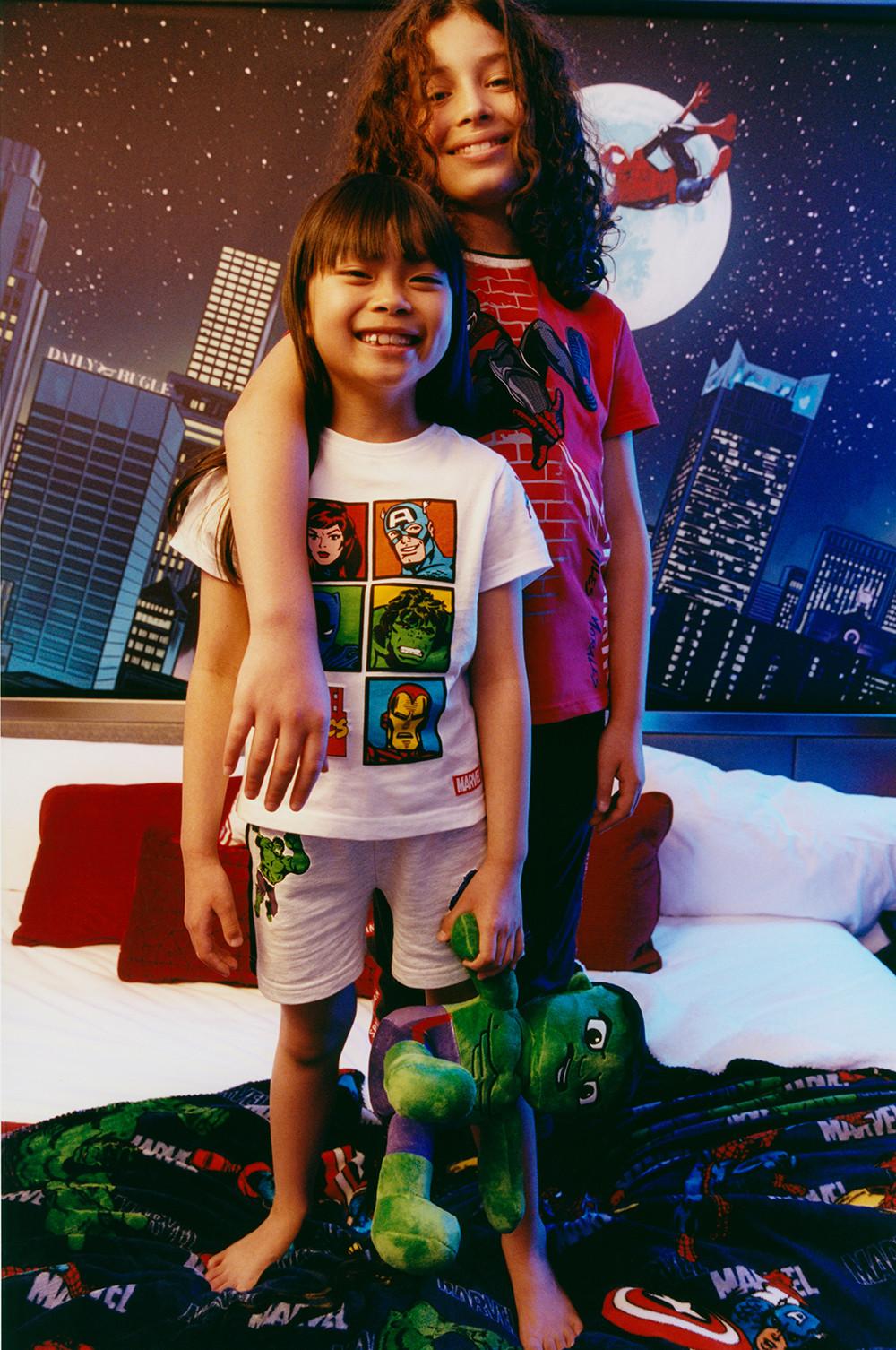 Kids wearing pyjama sets and holding a Hulk plush toy