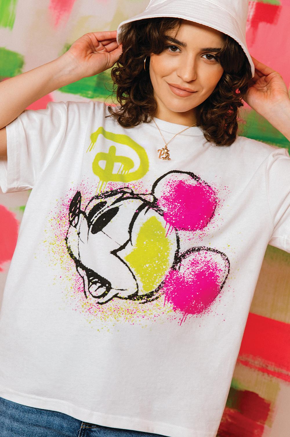 Modelo con camiseta blanca con estampado en tonos flúor de Mickey Mouse