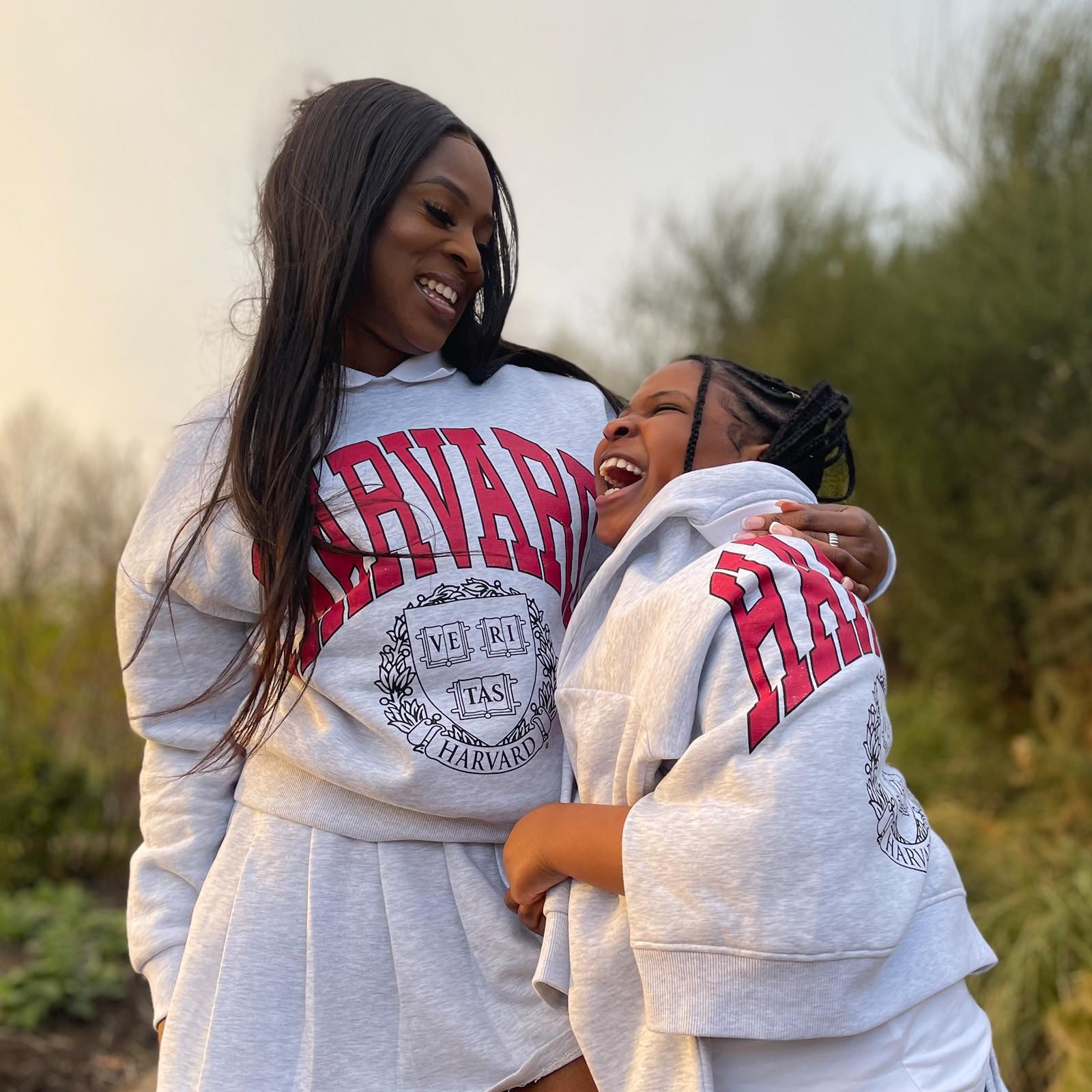 Mère et fille portant un sweat-shirt et une jupe Harvard déclinés dans le gris