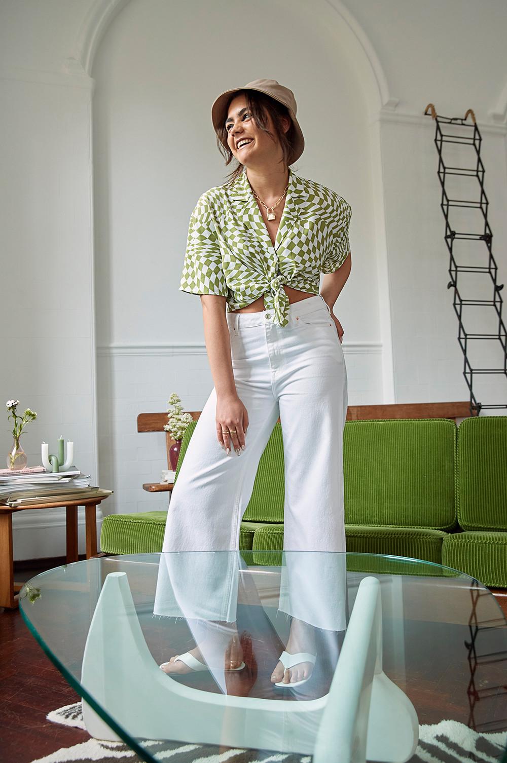 Modelo con camisa de cuadros, pantalones de pernera ancha y gafas de sol