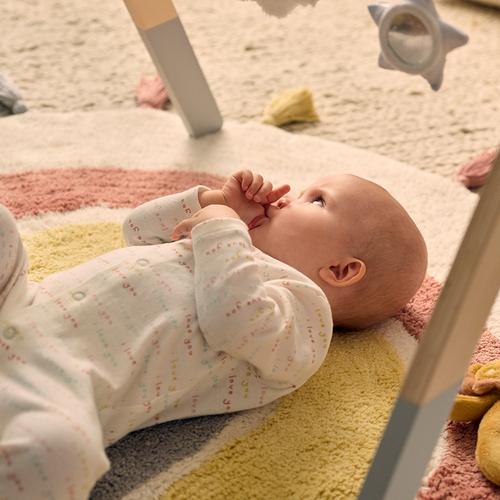 Baby on play mat sucking thumb